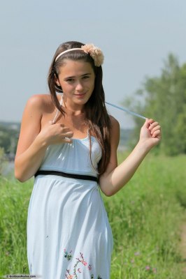 Tienermeisje trekt haar zomerjurkje uit en laat haar puntige borstjes zien