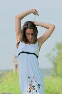 Tienermeisje trekt haar zomerjurkje uit en laat haar puntige borstjes zien