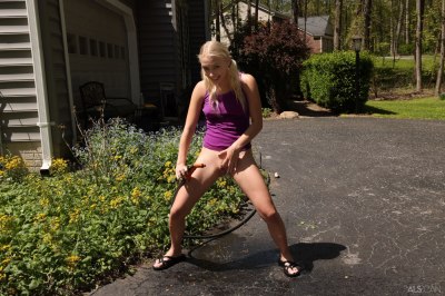 Blond meisje plast in haar achtertuin