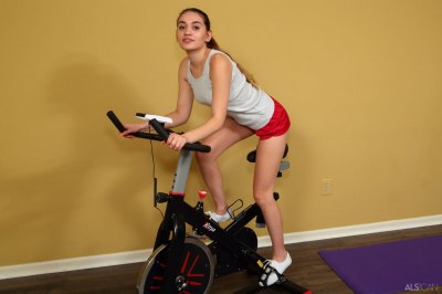 Sexy meisje traint naakt op hometrainer