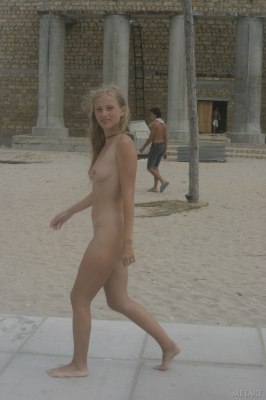 Waanzinnig mooi jong grietje loopt naakt over het strand