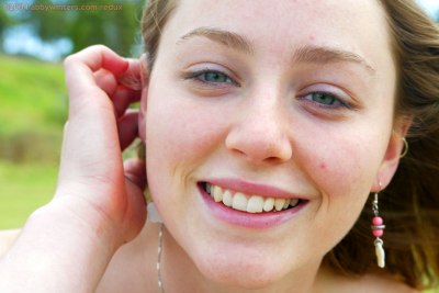 Paula met blote borsten buiten in het park