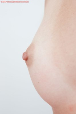 Eenentwintig-jarige jonge vrouw met tepelpiercing bloot