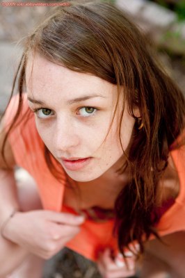 Slank meisje met buikspieren naakt in de achtertuin