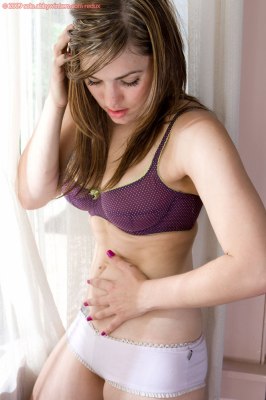 Jong verlegen meisje kleedt zich uit in de vensterbank