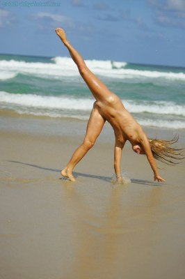 Mooie meid speels op het strand zonder bikini