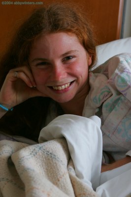 Meisje in bed doet haar pyjama uit en laat haar mooie tienerborstjes zien