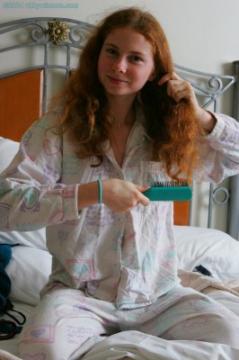 Meisje in bed doet haar pyjama uit en laat haar mooie tienerborstjes zien