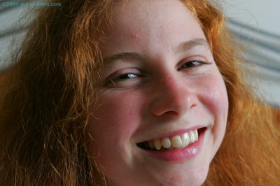 Meisje in bed doet haar pyjama uit en laat haar mooie tienerborstjes zien