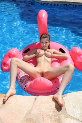 Blote meid op een flamingo zwemband